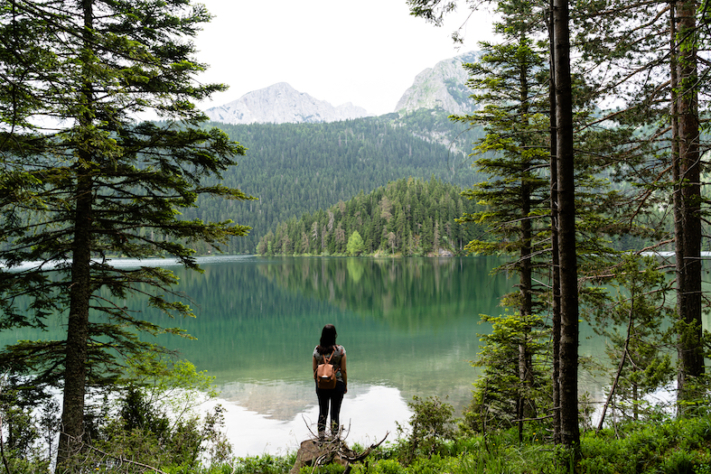 Bucket List: Frau schaut vor einem See in die Ferne.