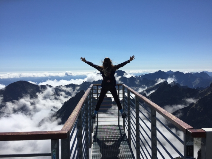 Frau genießt den Ausblick auf einem Berg