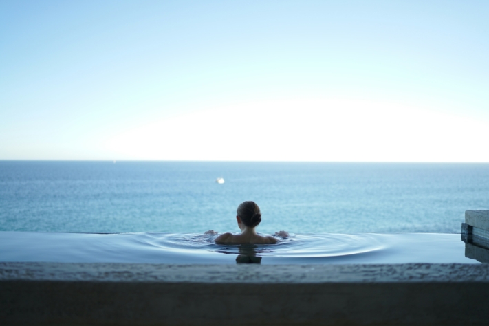 Lista de vacaciones: una mujer disfruta de las vistas al mar en una piscina