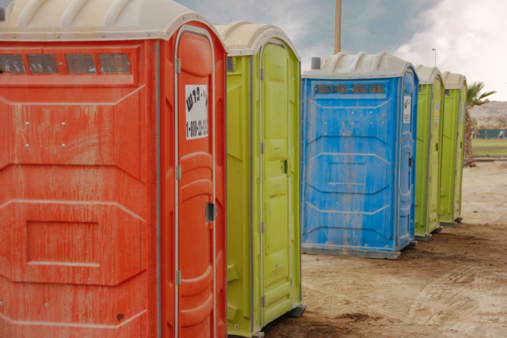 Colorful porta-potties on a dusty floor