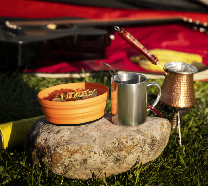 Bowl with muesli and cup stand on a stone
