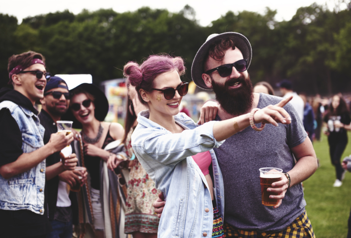 A woman shows her partner something at a festival