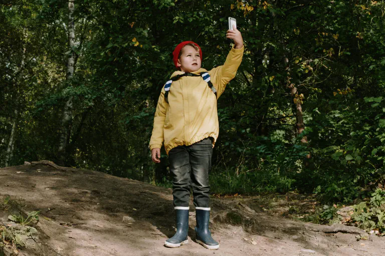 Un niño utiliza su smartphone para orientarse mientras practica geocaching