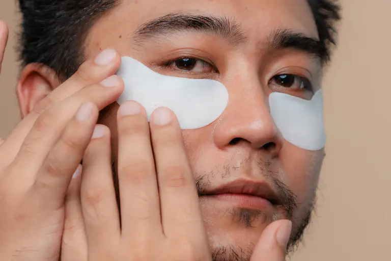 Homem com compressas refrescantes para os olhos