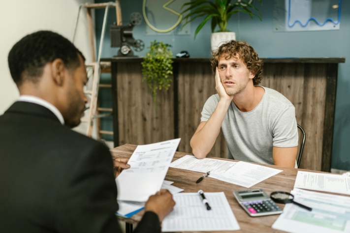 Klarna Schulden: Ein Mann sitzt einem Schuldnerberater gegenüber.