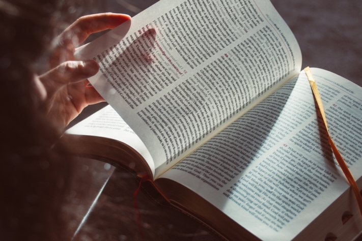 Eine Hand blättert in die Seite eines Buches um