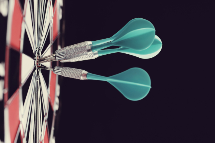 Dartpfeile stecken in der Mitte eines Dartboards