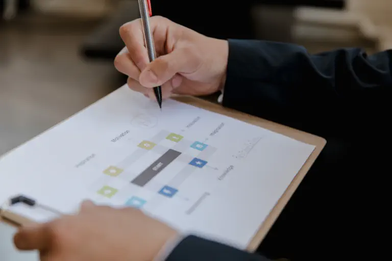 A person outlines the structure of a tool on a piece of paper.