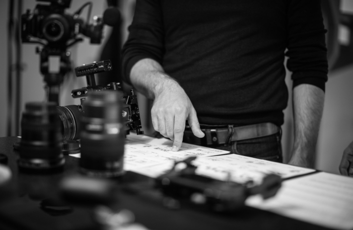 Regisseur zeigt mit seinem Finger auf das Storyboard