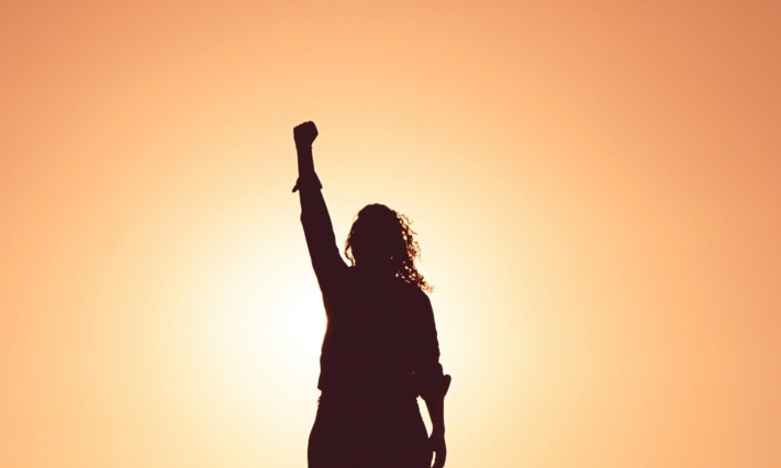 Analyse de la concurrence : Une femme prend la pose de la victoire sur un fond orange