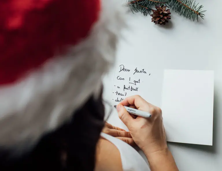 Criança a escrever a lista de desejos para o Natal